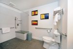 The shower area is large and has a bench to sit on.